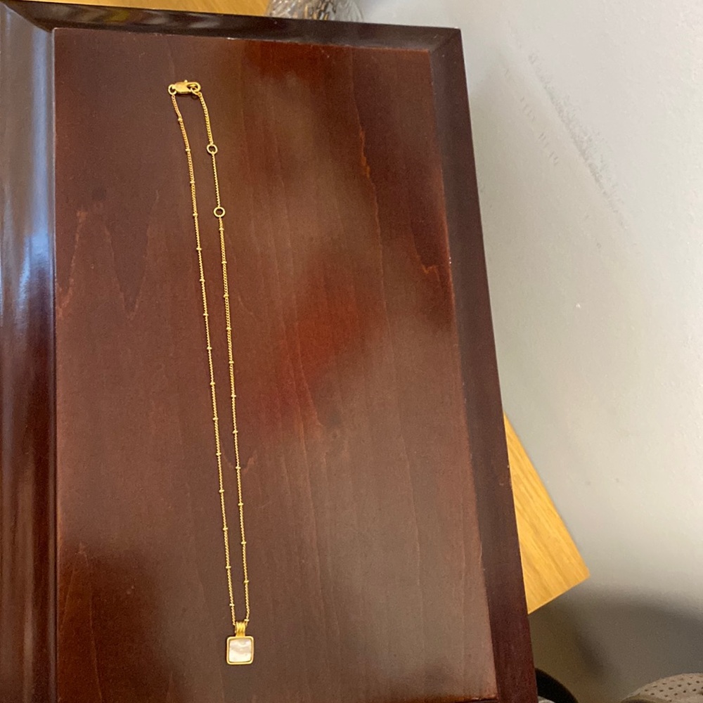 Gold beaded chain with pearly seashell square pendant.